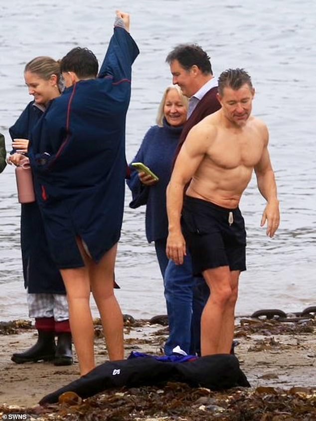 And donning his navy blue swimming trunks, the presenter showed off his toned six-pack and chiseled chest.