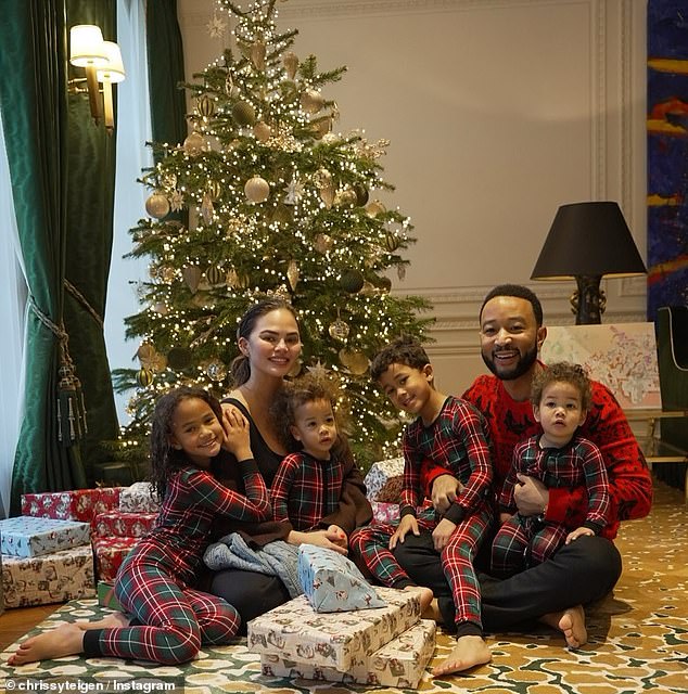 John Legend and Chrissy Teigen gathered around the tree on Christmas morning with their children Luna, eight, Miles, six, Esti, one, and Wren, one