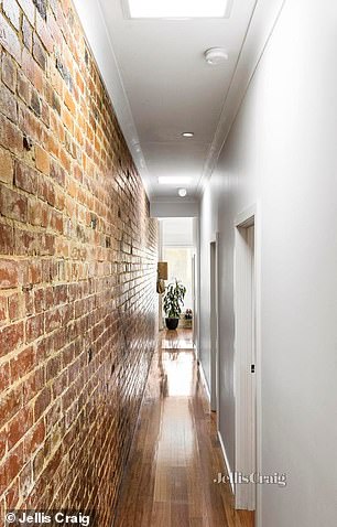 A striking feature is the exposed brick wall, which adds a rustic feel and runs like a visual thread throughout the property