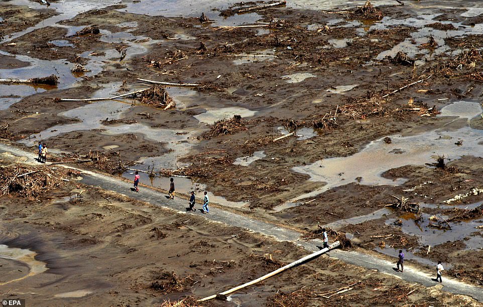 Survivors of the Asian earthquake and tsunami that struck the region on December 26 walk along a remote road in Indonesia