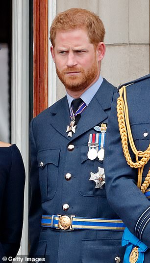 Prince Harry pictured in 2018 wearing full military fatigues with the Duchess of Sussex and Prince William at Buckingham Palace