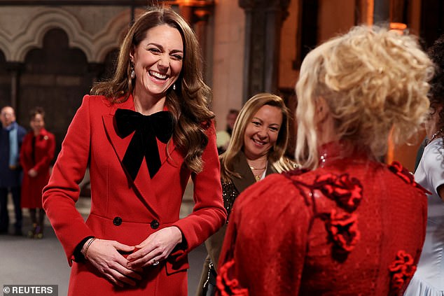 The Princess of Wales, pictured wearing an Alexander McQueen coat during the 'Together At Christmas' carol service - and talking to singer Paloma Faith, right