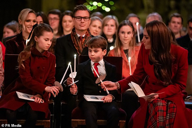 Princess Charlotte, Prince Louis and the Princess of Wales hold candles as they take their seats in Westminster Abbey during the service