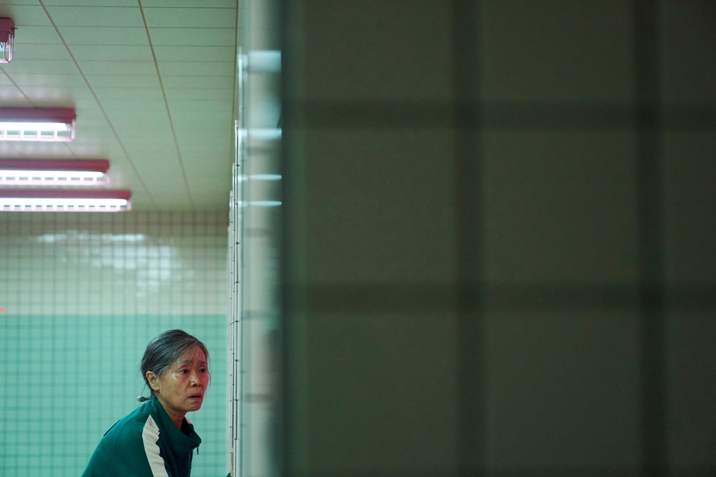 Geum-ja (Kang Ae-sim) looks worried in a bathroom in a still from Squid Game season 2