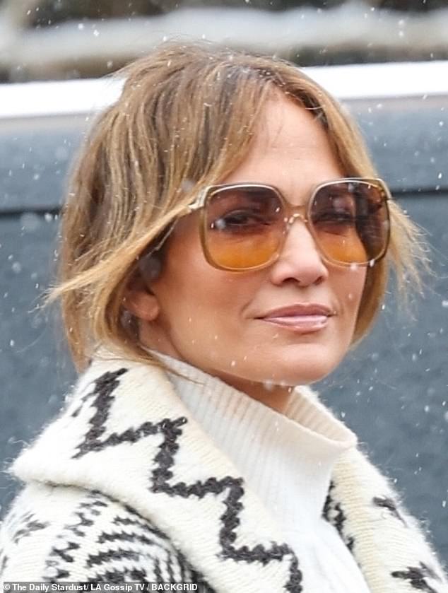 Jennifer wore a pair of retro 1970s sunglasses over her fully formed complexion, and she styled her real, authentic hair in a sparse, fringed updo.