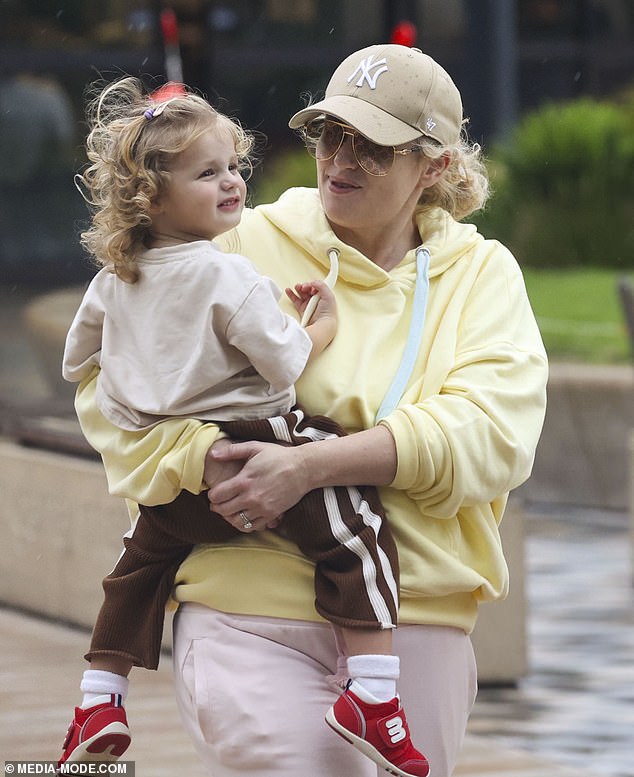 Rebel wore a loose-fitting lemon-colored hooded sweater that she paired with comfortable-looking light pink sweatpants