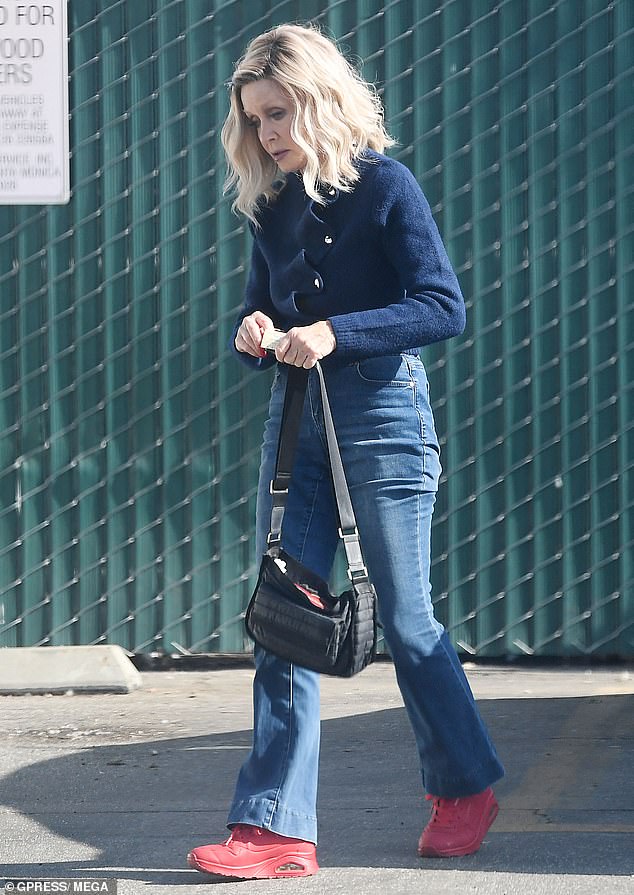 The Knot's Landing actress wore a blue sweater and fitted blue jeans that showed off her slim figure. She added red sneakers