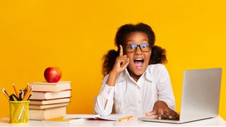 child in the classroom with a laptop