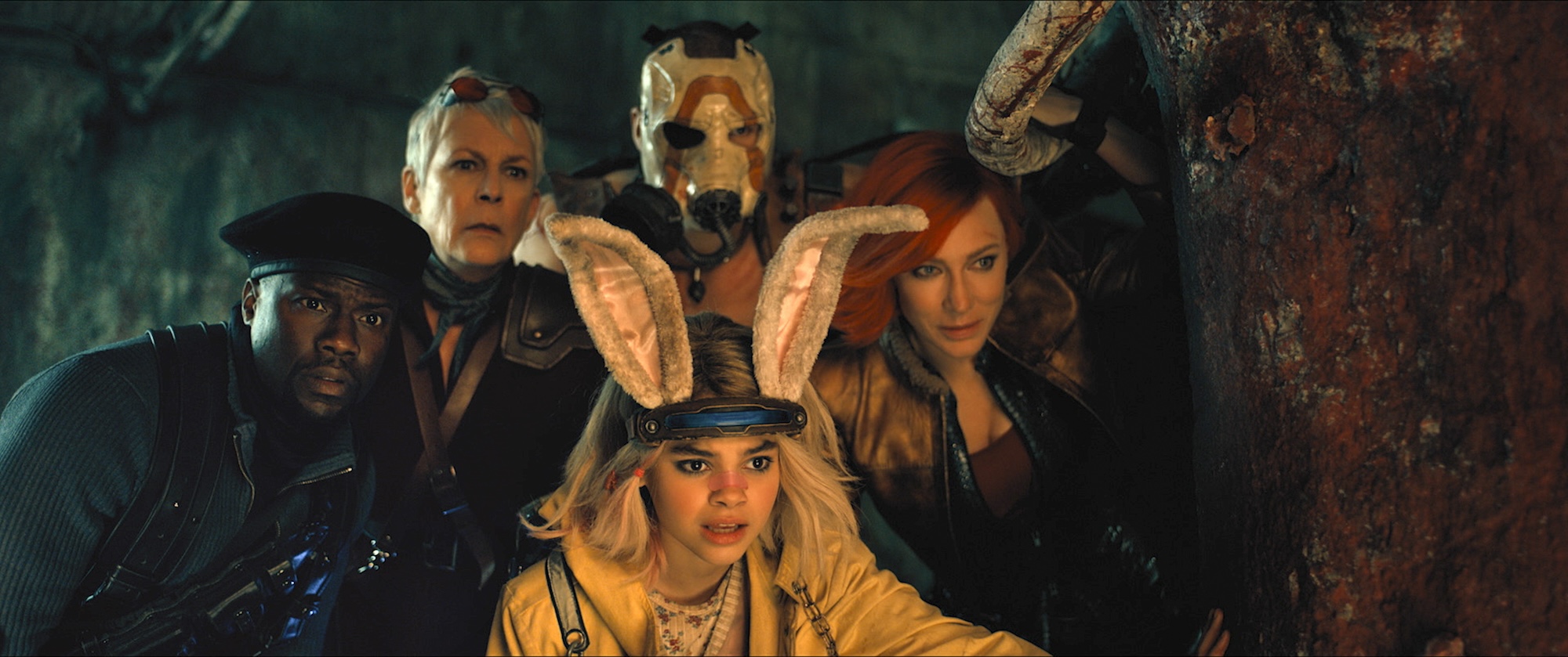 Kevin Hart as Roland, Jamie Lee Curtis as Tannis, Ariana Greenblatt as Tiny Tina, Florian Munteanu as Krieg and Cate Blanchett as Lilith in Borderlands. They're all strangely dressed and peering anxiously around a rusted metal structure.