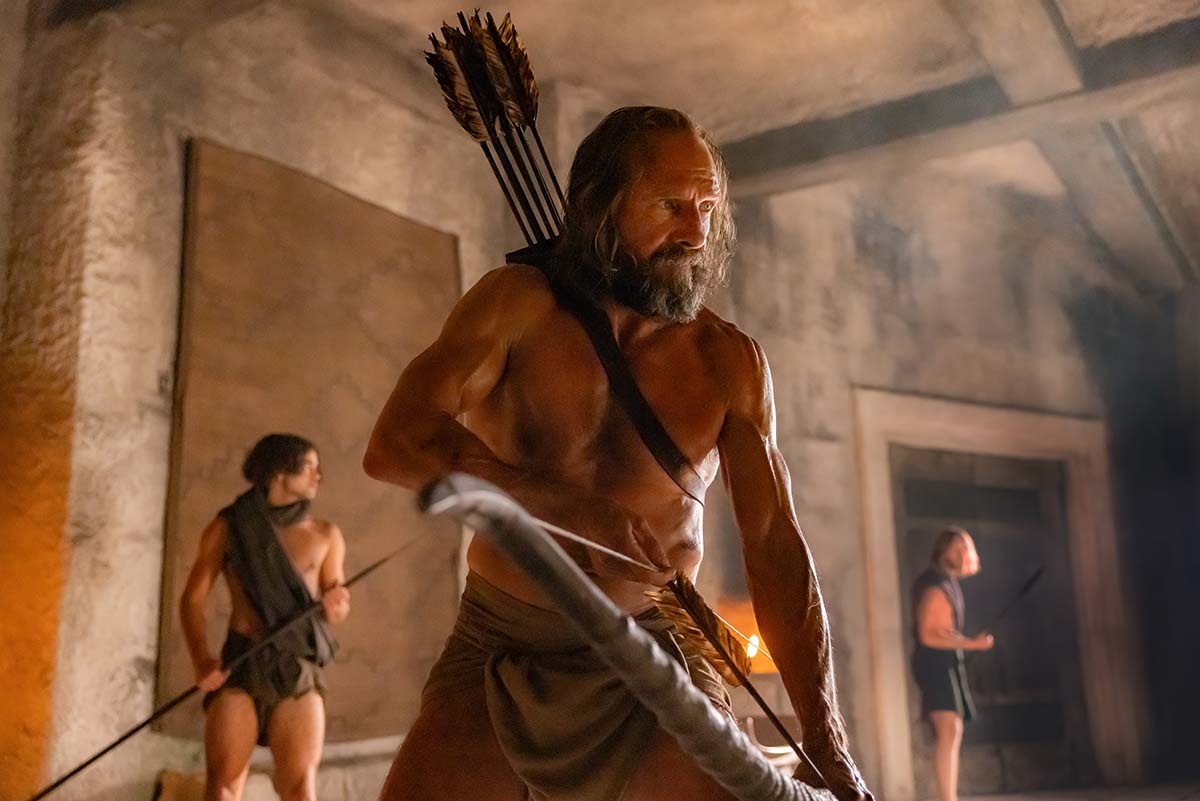 A shirtless Ralph Fiennes laying a snare in The Return