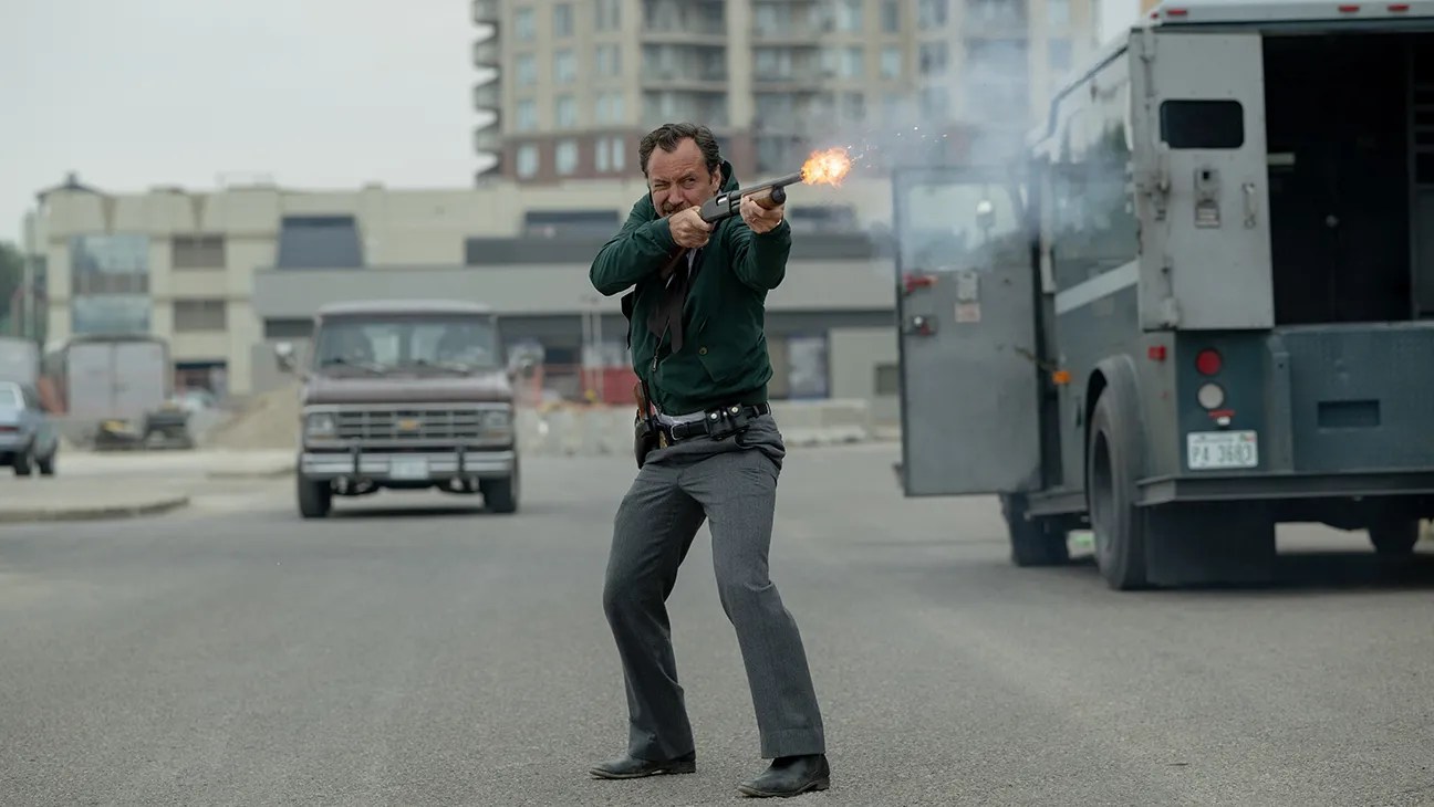 Jude Law fires a shotgun in the middle of the street in The Order