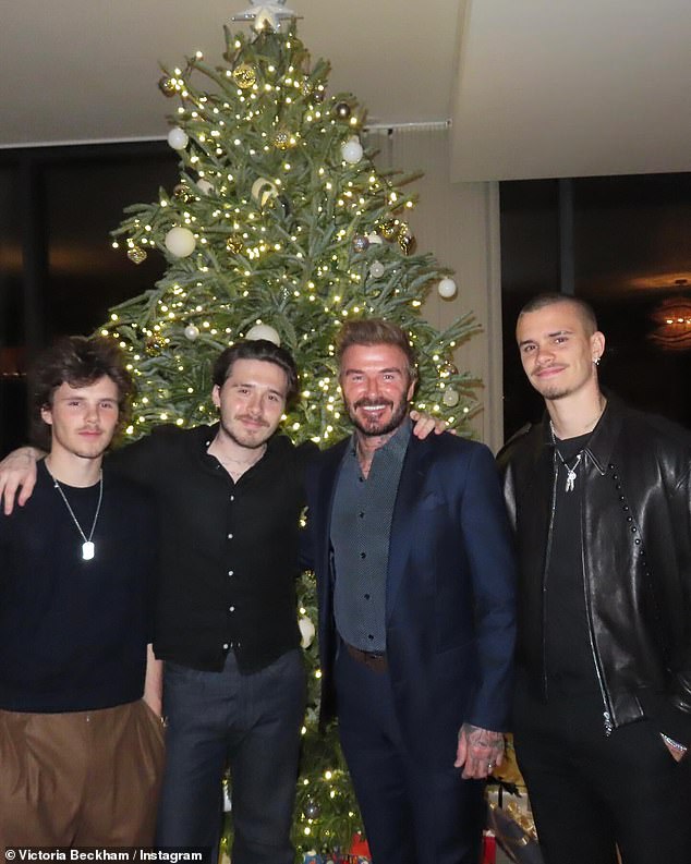 Former England great David looked dapper in a navy blue suit as he posed with his three sons