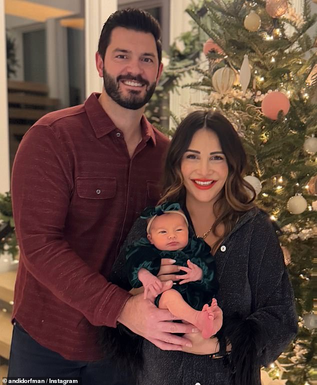 Andi shared an adorable photo as they posed with their little girl while standing in front of a decorated tree