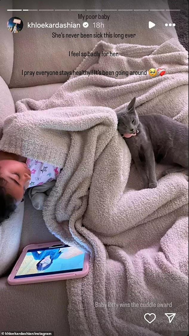 On Friday, the 40-year-old co-founder of Good American reported in her Instagram Story that the young person is still ill. She shared a clip from True Sound as she slept on a couch while wrapped in a blanket with their cat, Baby Kitty, cuddled next to her.