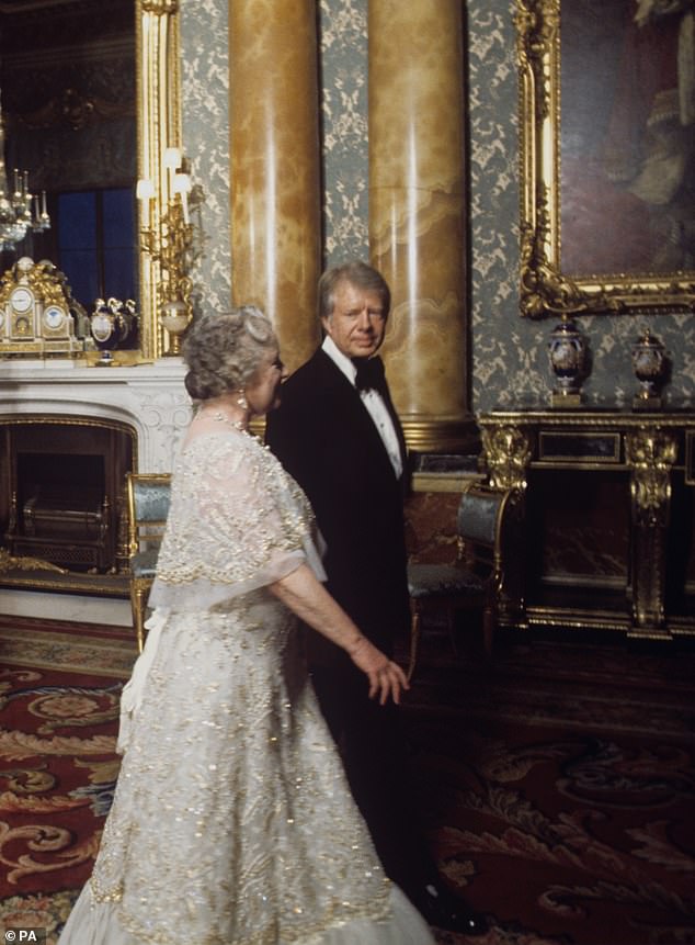 The Queen Mother walks with President Jimmy Carter, seen right, in the Blue Drawing Room of Buckingham Palace. The royal family received seven world leaders during a dinner