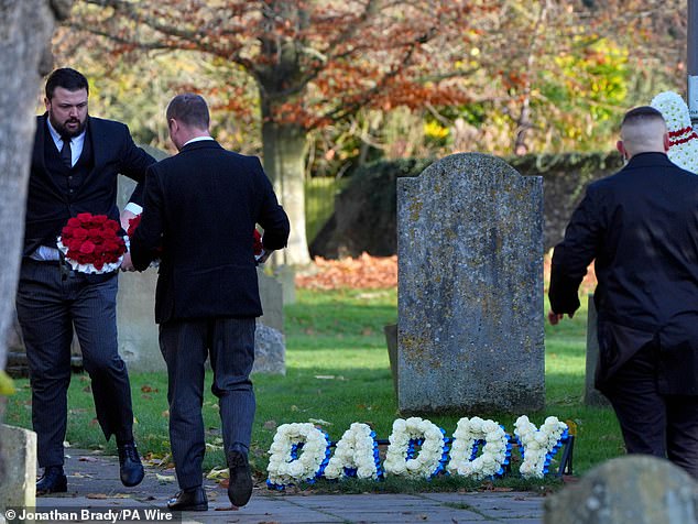 Funeral directors place a floral tribute that reads "Dad" outside One Direction singer Liam Payne's funeral service