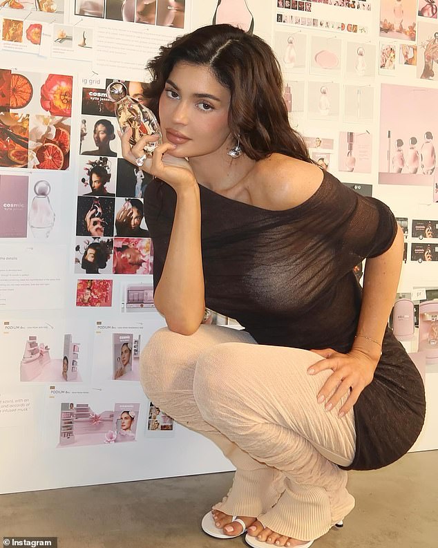 The beauty mogul shared a sexy photo of herself squatting in a sheer shirt while showing off her debut fragrance Cosmic.