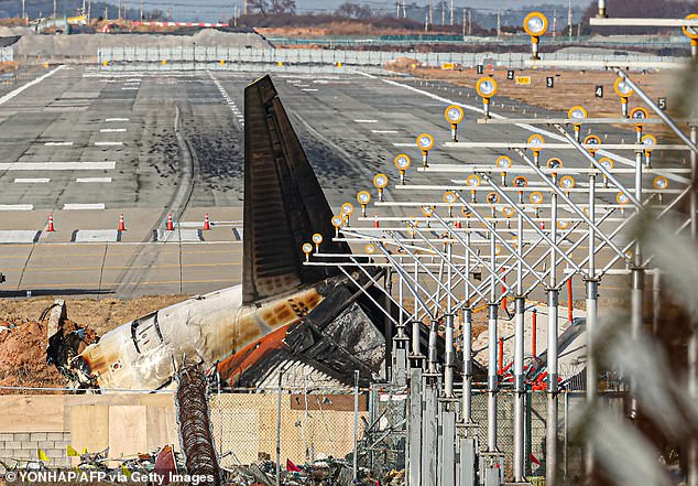 The destroyed tail section of the Jeju Air Boeing 737-800 aircraft that crashed and caught fire is seen at the end of the runway at Muan International Airport in Muan on December 30, 2024