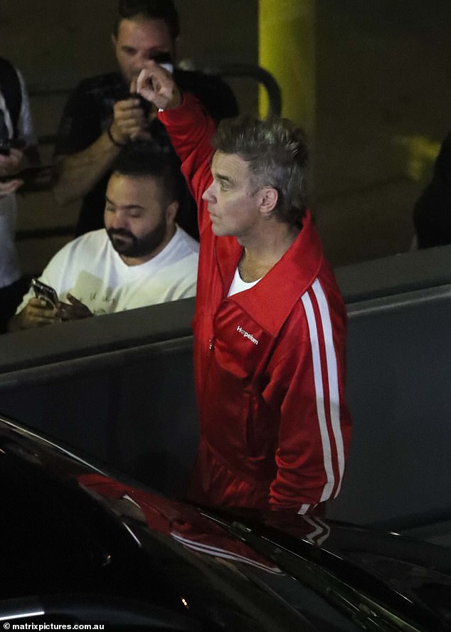 He added designer sunglasses to his nighttime look and carried his belongings in a black and white tote bag