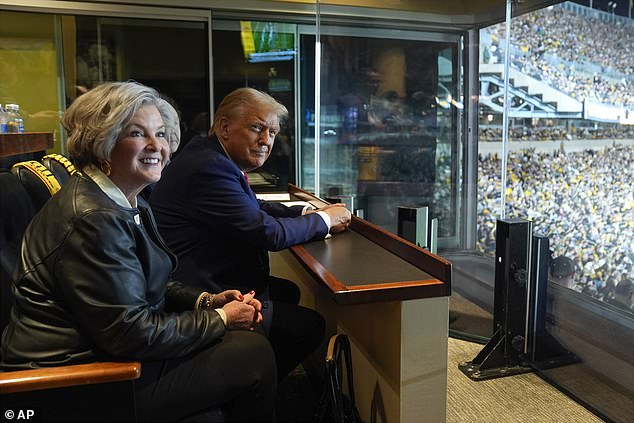 Republican presidential candidate, former President Donald Trump, sits next to Susie Wile