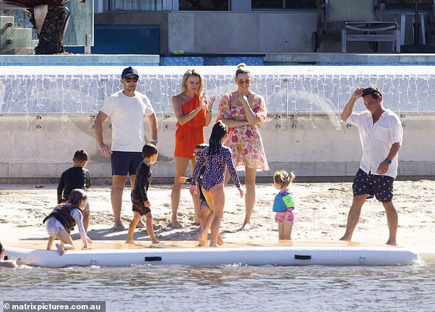 Karl's wife Jasmine (center right) watched their daughter Harper, four, play in the sand