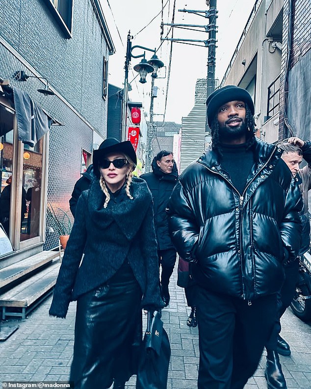 Madonna also shared a candid photo of her and her taller, younger boyfriend walking alongside her as they strolled through the quaint alleys with her crew.