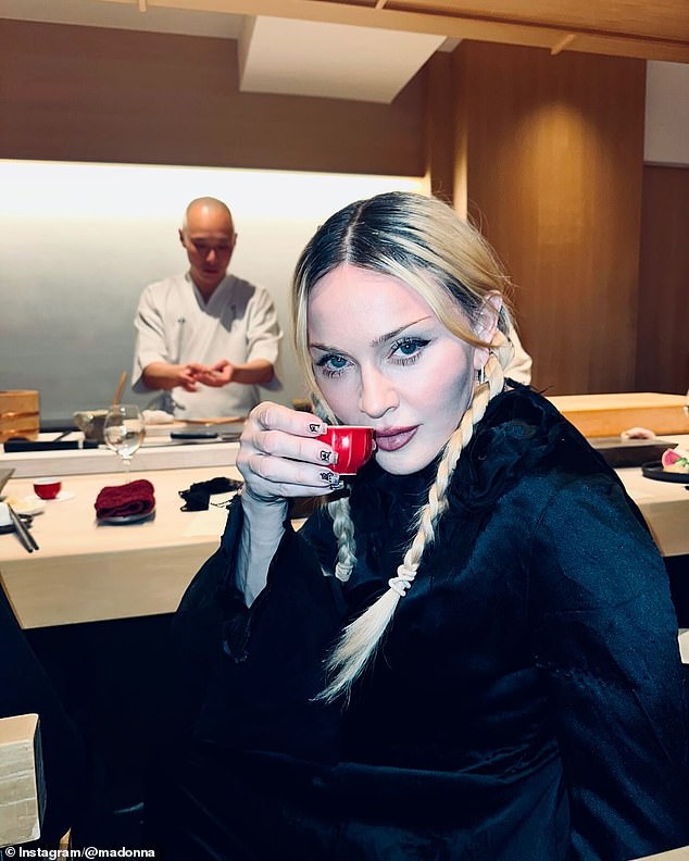 During their trip, Madonna also enjoyed an omekase meal, as seen in photos of her posing with a sake cup and as a sushi chef prepares her food behind her.