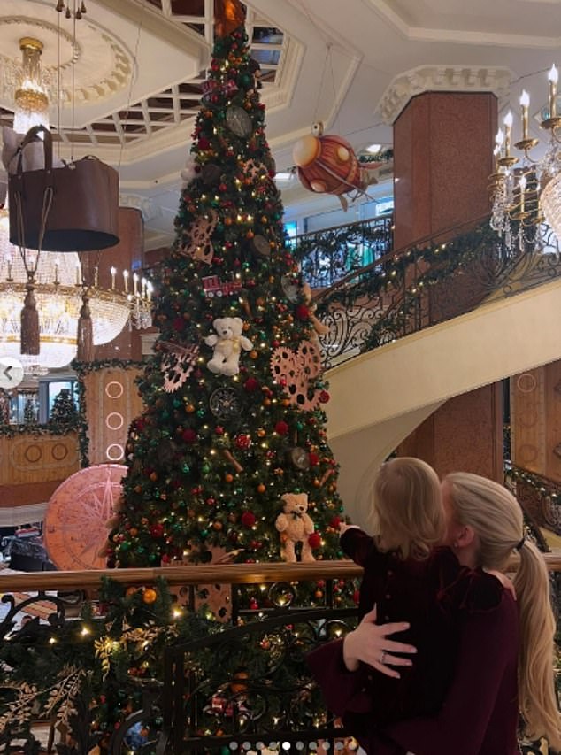 Photo: Lady Kitty lovingly cradles her daughter as they visit the lavishly decorated Christmas trees