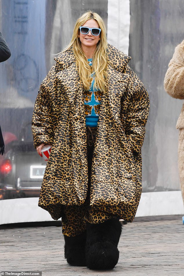 She modeled a $760 oversized Free People leopard print coat, a blue sweater with tiger head designs and matching snow pants