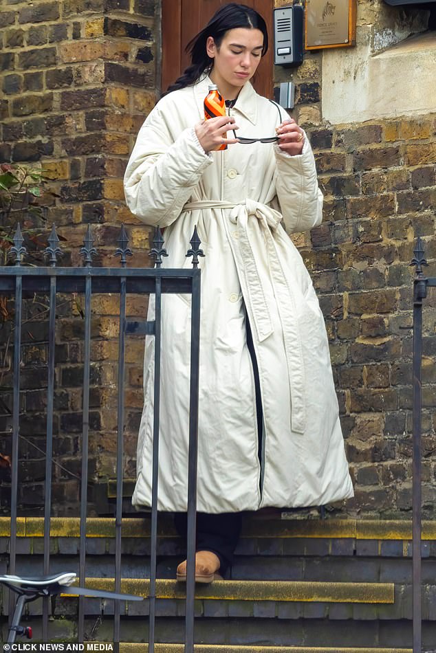 The pop star dressed up for the outing in a white trench coat which she wore with black pants and a pair of tan UGG boots