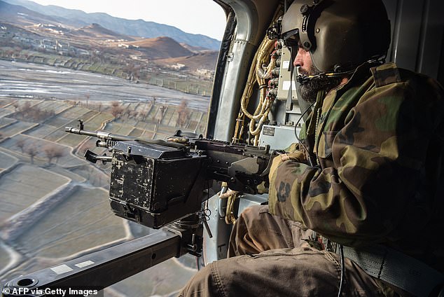 A Taliban security personnel stands guard from a helicopter two days after the air strikes by Pakistan