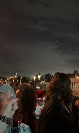 As Tik Tok user @DisneyDads points at the UFO or UAP, others begin to turn around and see the strange, red glowing object