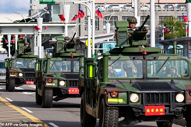 Armed military vehicles patrol outside Taipei's Songshan Airport after China deployed fighter jets and warships to encircle Taiwan on October 14. 