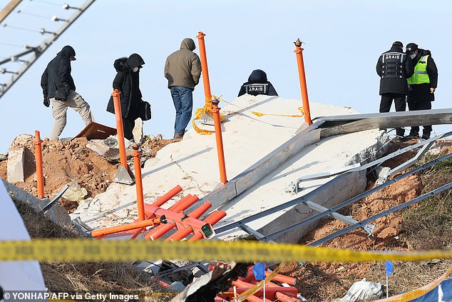 Investigators, including officials from South Korea's Aviation and Railway Accident Investigation Board (ARAIB), the U.S. National Transportation Safety Board (NTSB), and aircraft manufacturer Boeing, stand near the hill where the instrument landing system localizer is located, where the Jeju Air Boeing 737 capable -800 aircraft crashed