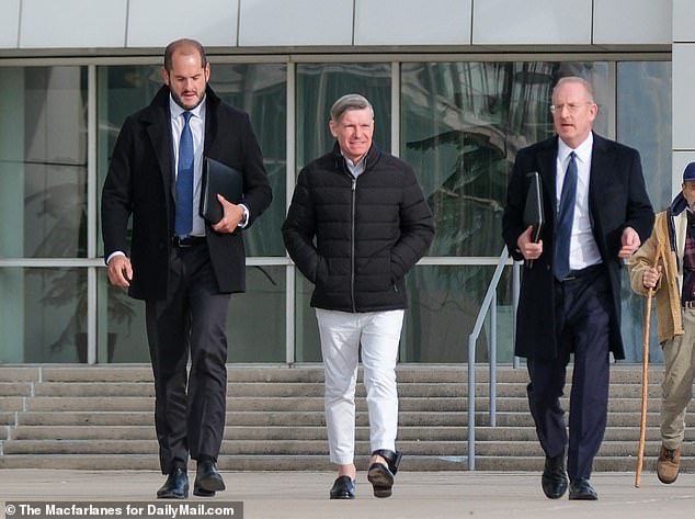 Matthew C. Smith (center) leaves his arraignment wearing an ankle monitor at Central Islip Federal Court in New York