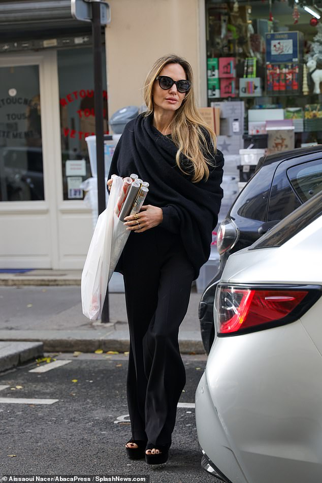 Angelina Jolie looked chic in an all-black ensemble as she ventured out for some Christmas shopping in Paris on Sunday