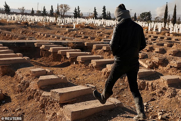 A local Tadamon walks past the site of a mass grave from Bashar al-Assad's rule in Syria