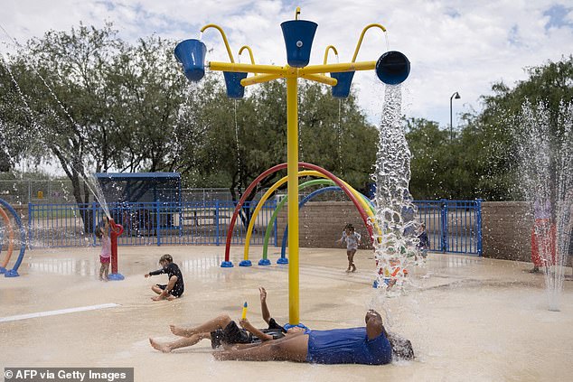 People who use splash pads may be at greater risk of contracting diseases, scientists say. Above are adults and children using a splash pad in Arizona during a heat wave in July 2023