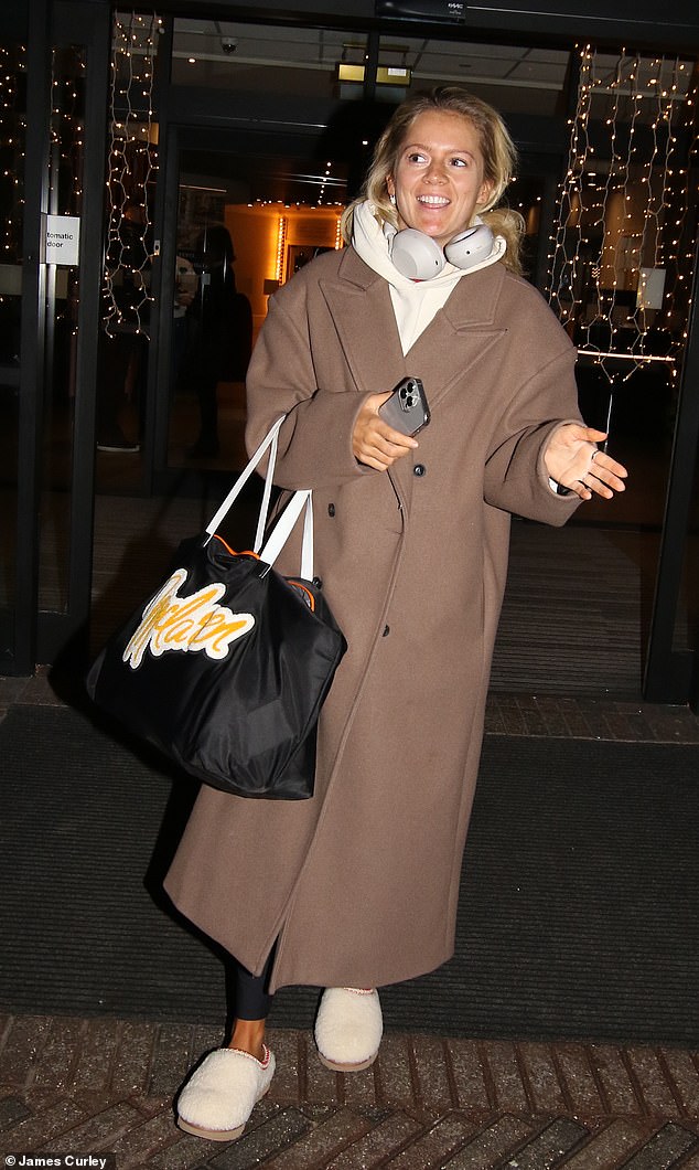 Tasha Ghouri looked pleased as she left the hotel in a long brown coat, pink hoodie and blue leggings, complete with a pair of cozy fluffy slippers and an oversized tote bag