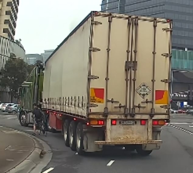 The video showed the driver stopping at the zebra crossing to make way for the semi-trailer (pictured left) as the truck entered the merge lane to head towards the highway