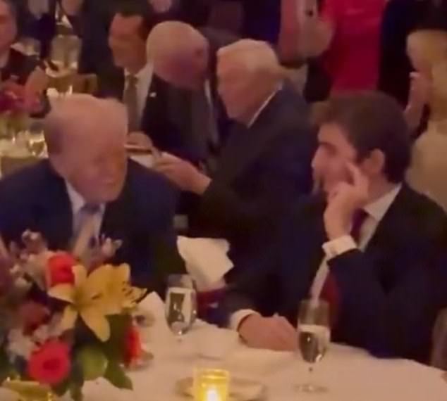 Barron Trump speaks with his father during a Thanksgiving dinner at Mar-a-Lago on Thursday