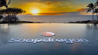 Snapdragon sign and logo in an infinity pool with Hawaiian sunset behind it