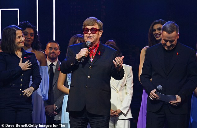 (L to R) Shaina Taub, Sir Elton John and David Furnish speak on stage "The devil wears Prada Musical" charity gala evening in support of the Elton John Aids Foundation at The Dominion Theater on December 1, 2024 in London, England