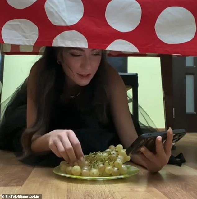 Liliana Tuskia also took part in the bizarre ritual, filming herself sitting under a table and shoving twelve grapes into her mouth - one for each month of the year