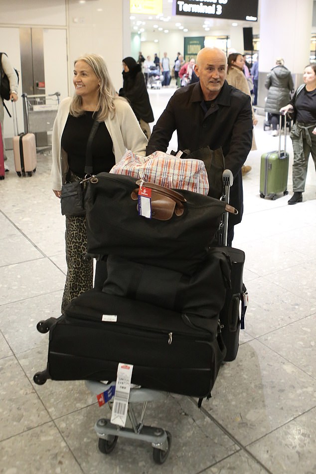 The former professional boxer, 63, was accompanied by his wife Sandra as he landed at Heathrow Airport after the long journey back