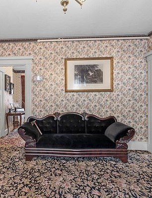 Pictured: The room where Andrew Borden's body was found. He was found on a couch, but the couch above is reportedly a replica. Lizzie Borden is said to have burned the original couch