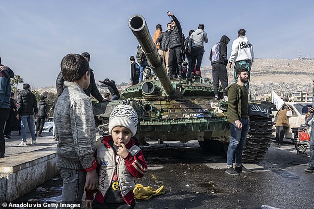 People celebrate the collapse of 61 years of Baath Party rule as they gather in Umayyad Square after armed groups opposing Syria's Bashar al-Assad regime took power in Damascus, Syria on December 9, 2024