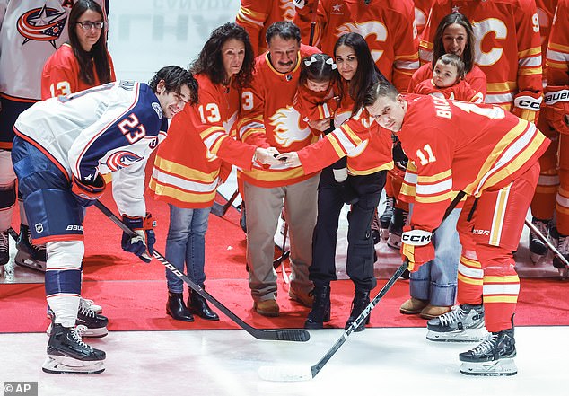 Columbus Blue Jackets' Sean Monahan (left) and Calgary Flames' Mikael Backlund join Johnny Gaudreau's family at center ice prior to Tuesday's game. Monahan (left) is seen crying