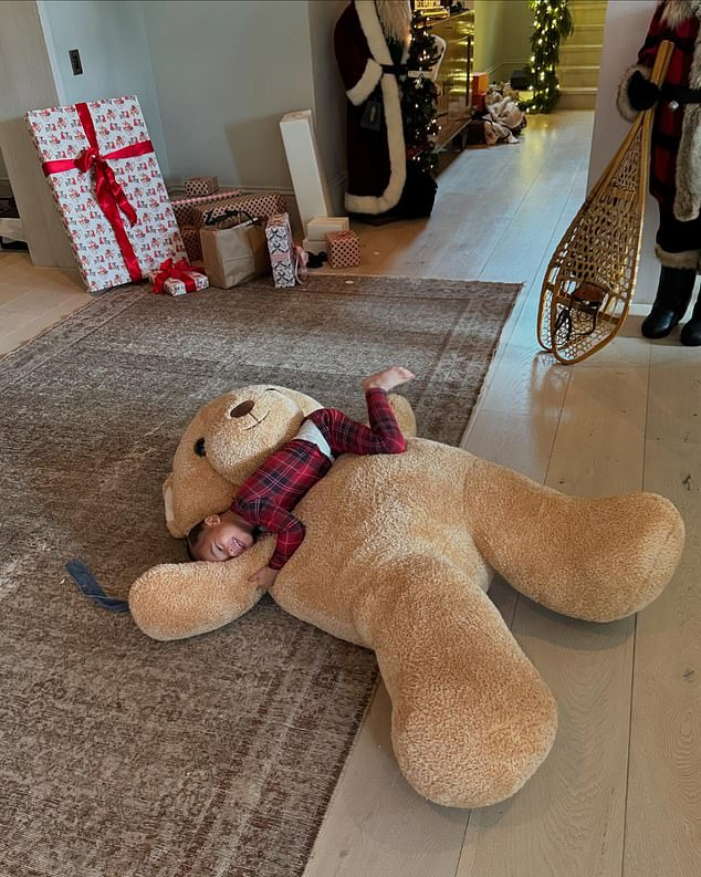 In another photo of the toddler, Aire flashed a sweet smile as she lay on a giant brown teddy bear in the foyer of Jenner's $60 million Hidden Hills mansion