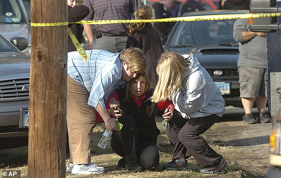 People are comforted at Sandy Hook Elementary School, December 14, 2012 in Newtown, Conn. Conspiracy theorist Alex Jones is asking the judge for permission to convert his personal bankruptcy reorganization into a liquidation, which would lead to a sell-out of much of the company. his ability to help pay some of the $1.5 billion he owes to relatives of the Sandy Hook Elementary School shooting victims. (AP Photo/Hearst Connecticut Media, Alex von Kleydorff via AP, File)